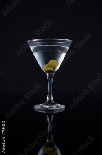 Cocktail martini with olives on table