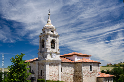 Old stone church in spain with blue sky and some clouds in the background
