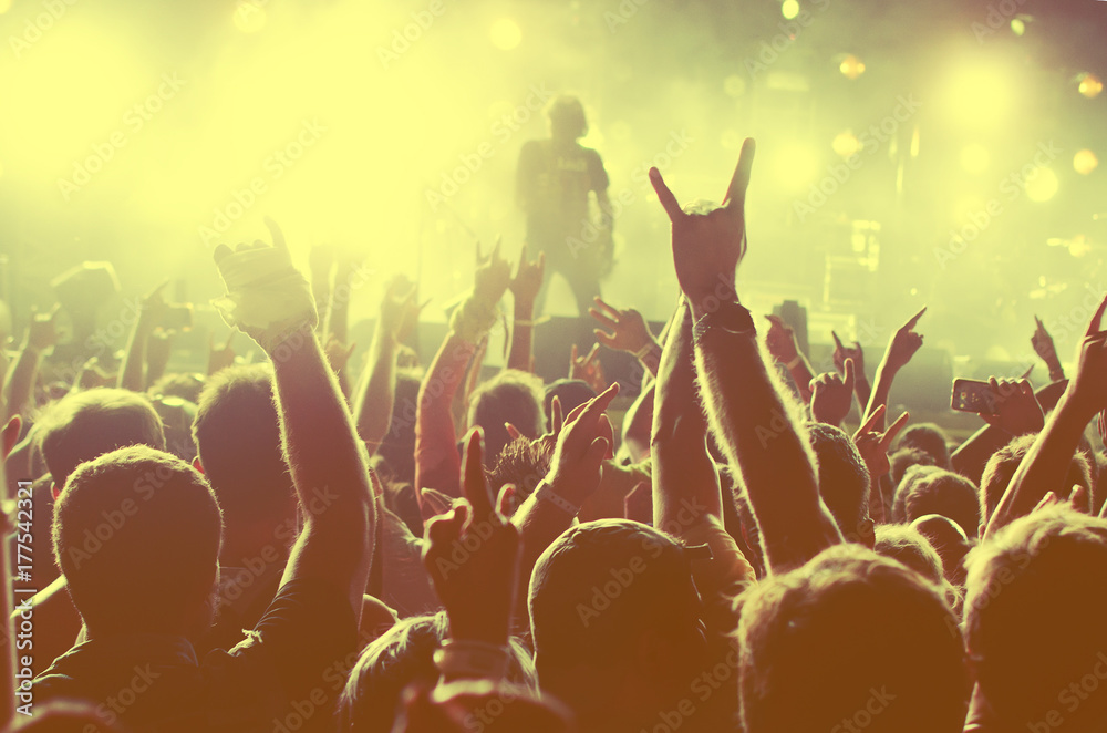 Concert Crowd. Silhouettes young people in front of bright stage lights. Band of rock stars
