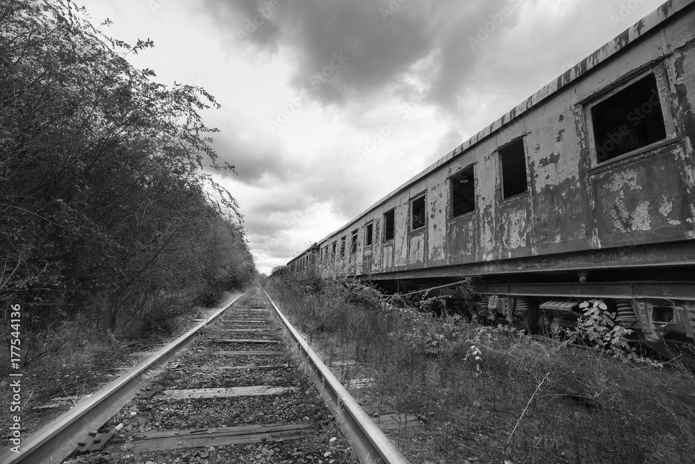 Hopeless post apocalyptic landscape. Cemetery of abandoned broken trains. Monochrome photo.