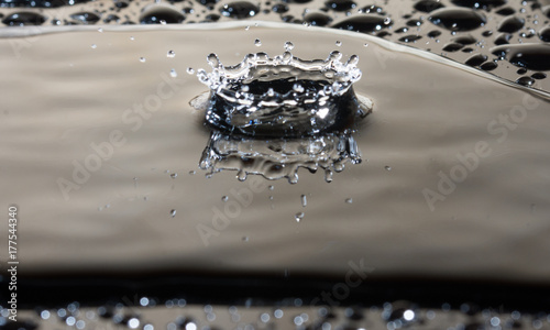 Goccia d'acqua che cade al suolo e forma una corona. photo