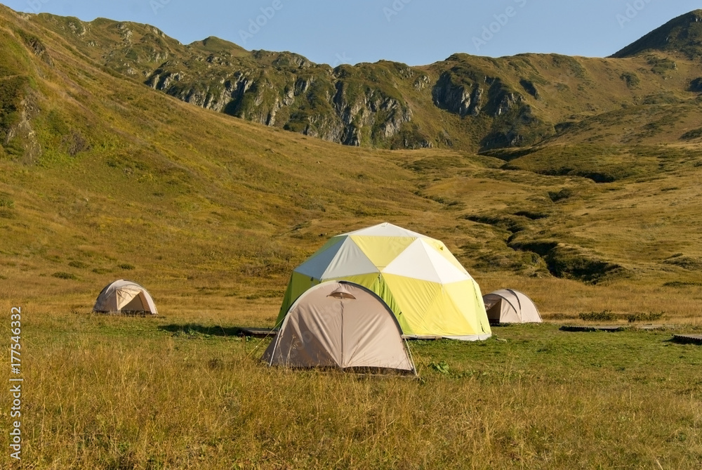 one patient and three small dome tents in the mountain valley