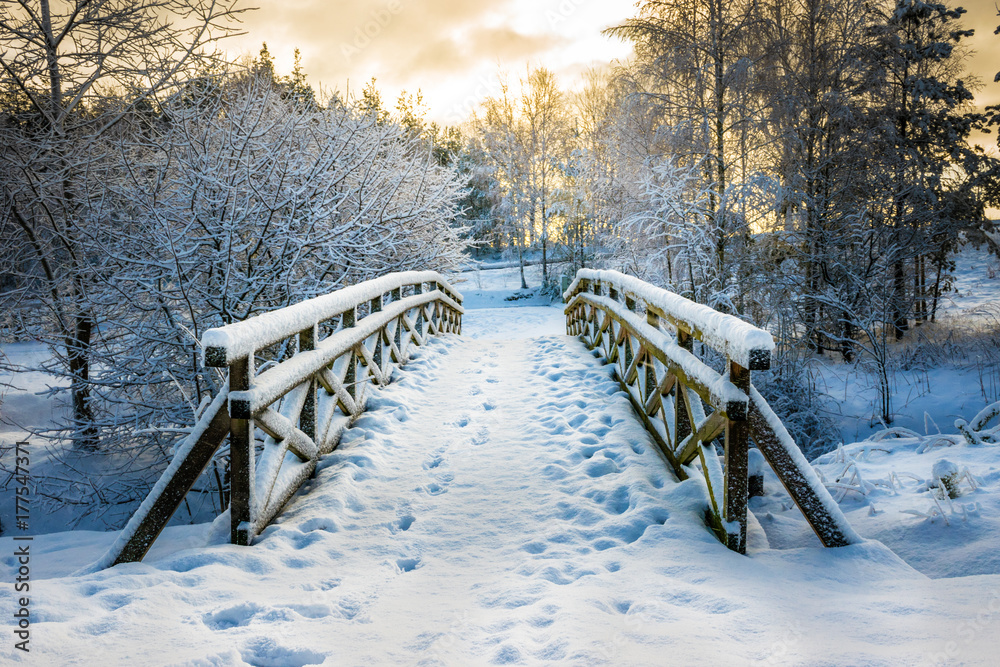 Naklejka premium Snowy, wooden bridge in a winter day. Stare Juchy, Poland