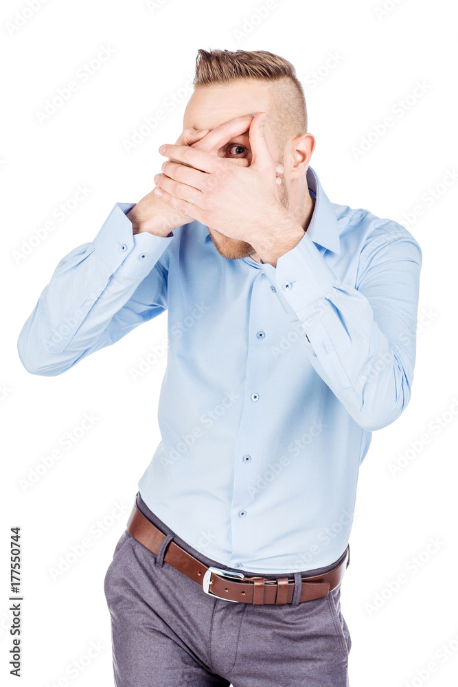 Man Peeps Through his Fingers. Isolated on the White Background Man Peeps Through his Fingers. Isolated on the White Background