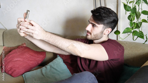 Young man using cell phone to take selfie photo