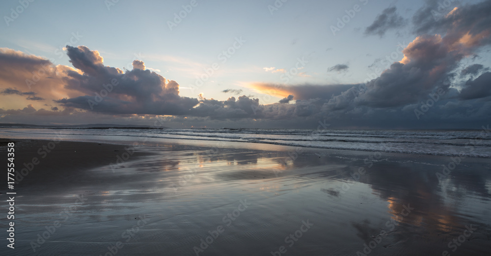 Stormy skies in the distance of west coast beach in Ireland at sunset