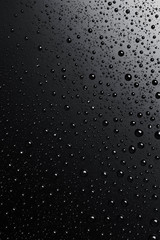 Water drops on a black surface, abstract background.