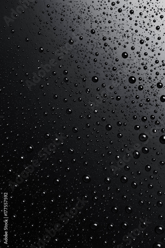 Water drops on a black surface, abstract background.