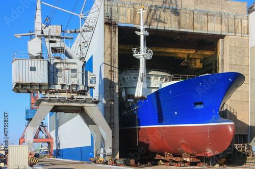 With the help of a crane, shipbuilders install the equipment of a new vessel