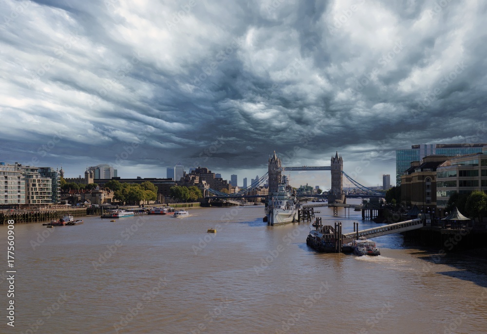 River Thames in London, with Tower Bridge in the distance with a cloudy ominous sky