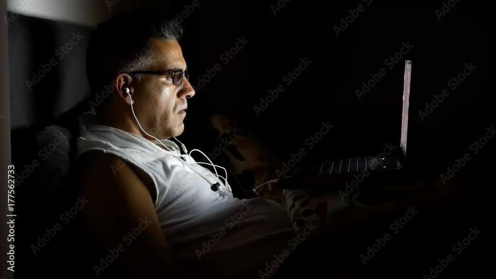 Man using and staring at computer screen at night Man using and staring at computer screen at night