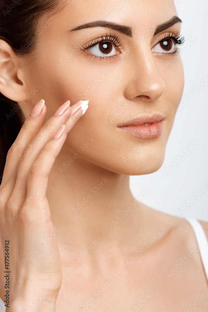 Facial Care. Female Applying Cream.Portrait Of Young Woman With Cosmetic Cream On Skin. Closeup Of Beautiful Girl With Beauty Product On Soft Skin, Natural Makeup Touching Face. High Resolution Facial Care. Female Applying Cream.Portrait Of Young Woman With Cosmetic Cream On Skin. Closeup Of Beautiful Girl With Beauty Product On Soft Skin, Natural Makeup Touching Face. High Resolution