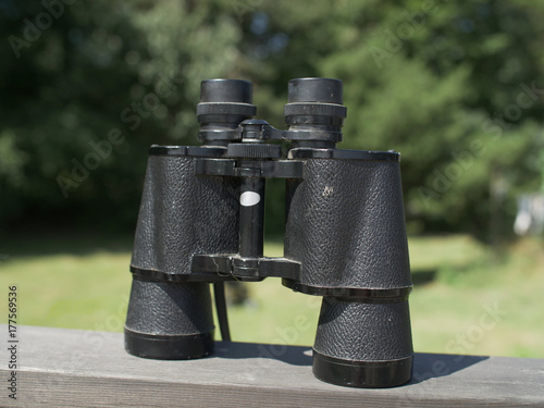Vintage binocular on wooden boards with nature in the background