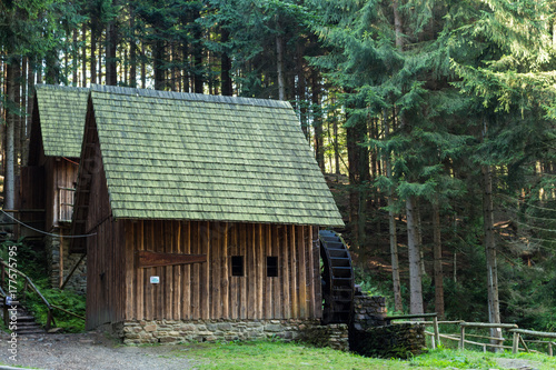 Western style pioneer frontier water mill wheel wooden building in the forest