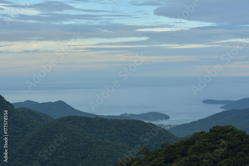 Vista de Ubatuba de cima da Serra do Mar, com camadas de montanhas azuis que acabam no mar.  © dririchetto