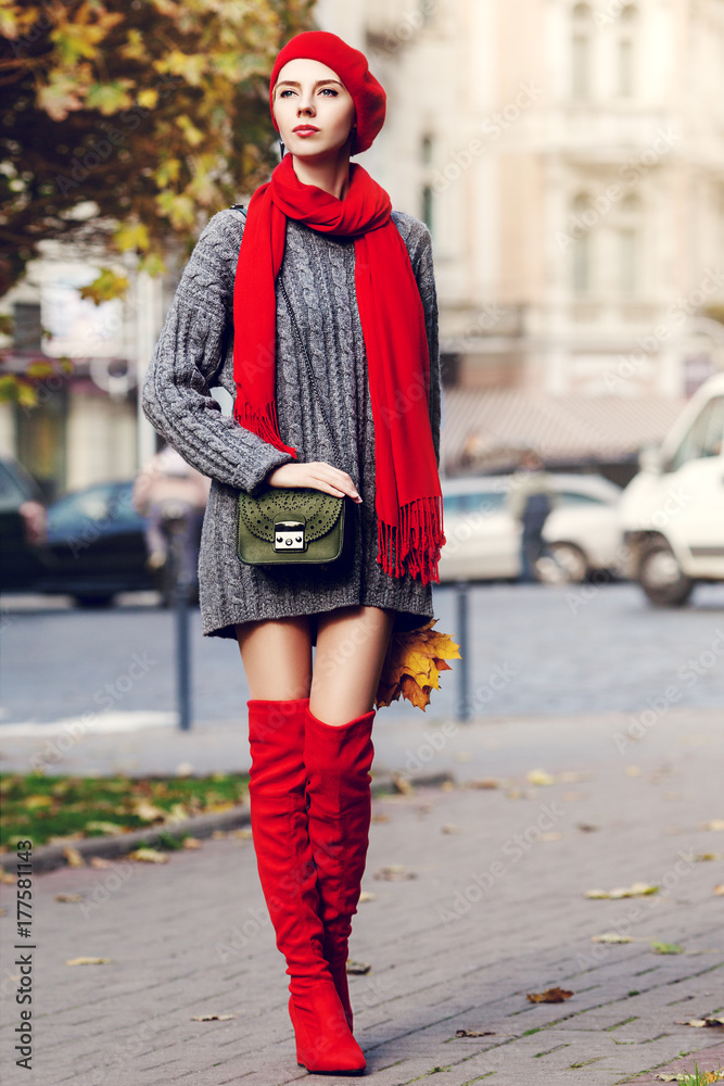 Outdoor full body portrait of young beautiful fashionable woman wearing  trendy red high, over knee boots, stylish clothes and accessories. Model  posing in street. Elegant autumn outfit. Female fashion foto de Stock