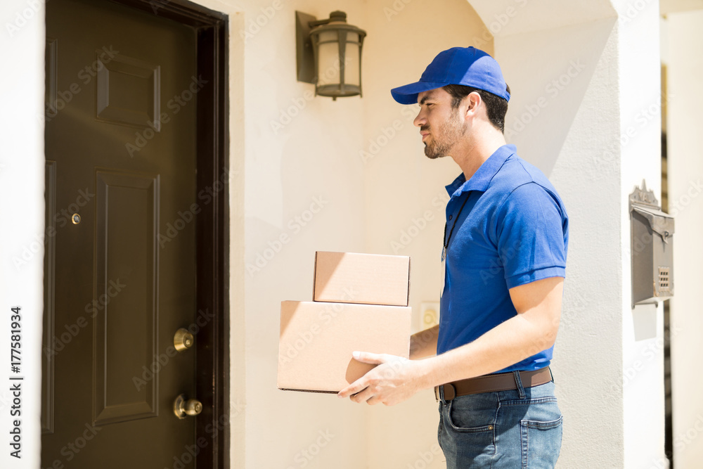 Delivery guy waiting outside a house with some packages Delivery guy waiting outside a house with some packages
