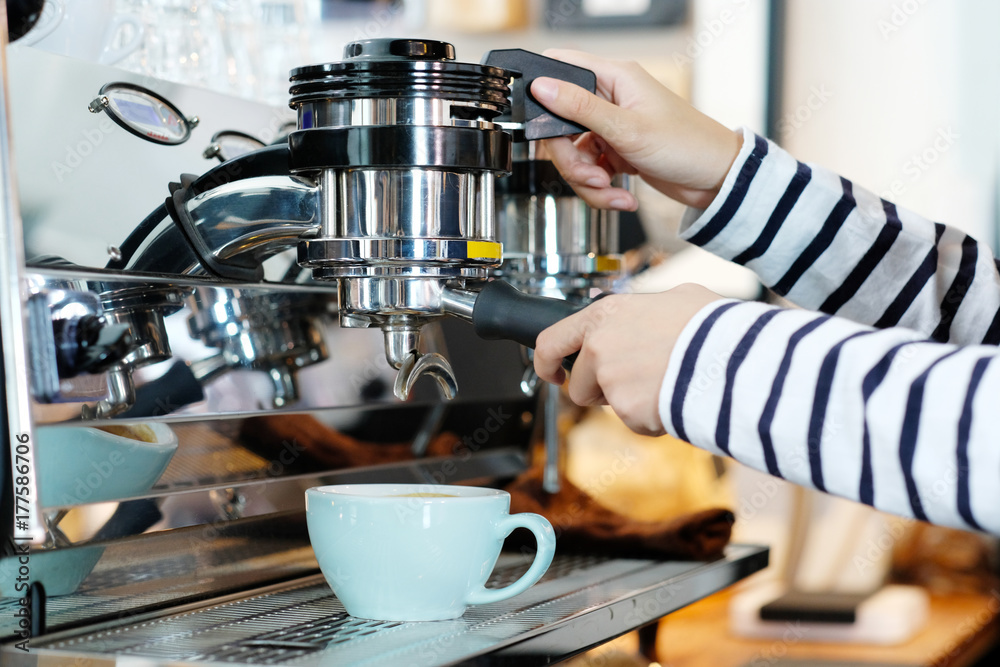 Woman hand using coffee machine at cafe counter, food and drink concept Woman hand using coffee machine at cafe counter, food and drink concept