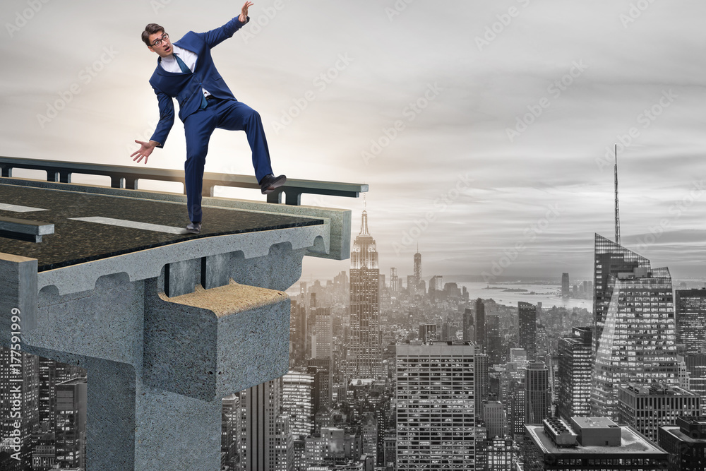 Businessman in uncertainty concept with broken bridge Businessman in uncertainty concept with broken bridge