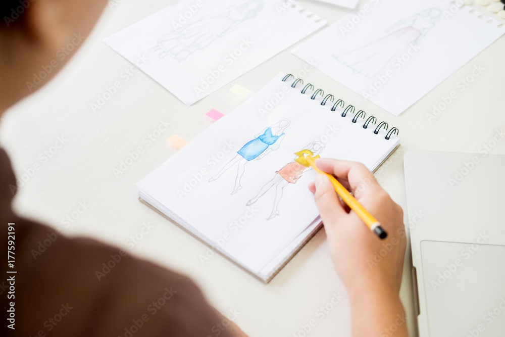 young women working as fashion designer drawing sketches for clothes in atelier paper at workplace studio. young women working as fashion designer drawing sketches for clothes in atelier paper at workplace studio.