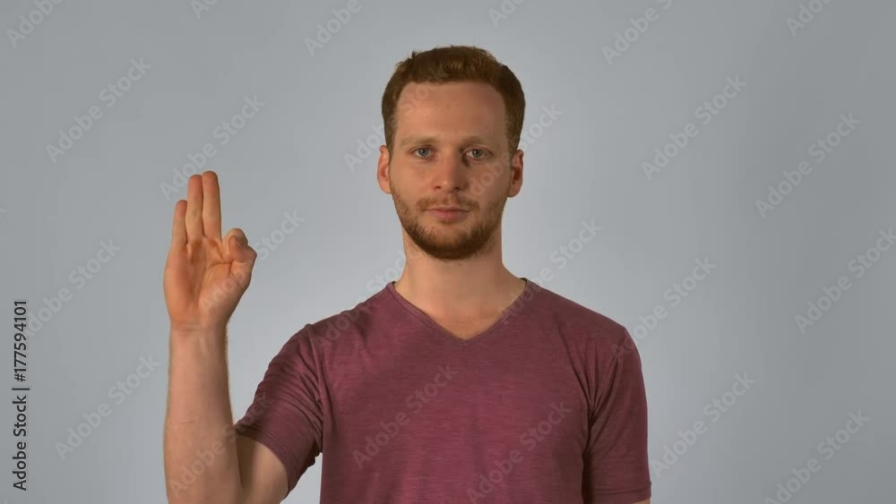 portrait happy young caucasian man on grey background chinese number gestures. caucasian guy with red hair make a gesture with the hand shows the countdown from five to start. handsome redhead men portrait happy young caucasian man on grey background chinese number gestures. caucasian guy with red hair make a gesture with the hand shows the countdown from five to start. handsome redhead men