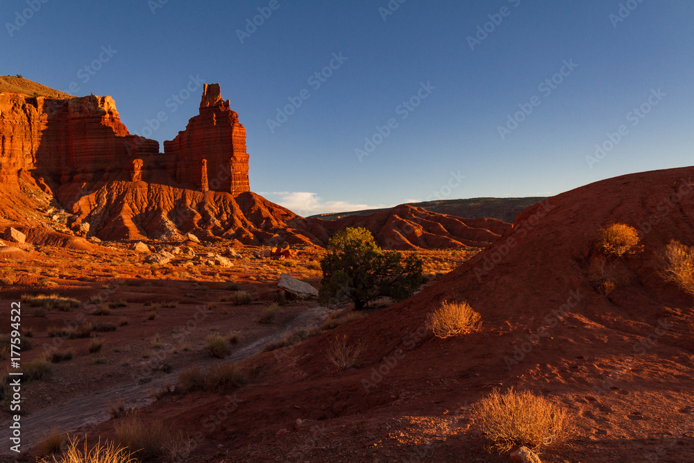Moody red Chimney Rock and shadowy trail at Capitol Reef National Park in Utah. Moody red Chimney Rock and shadowy trail at Capitol Reef National Park in Utah.