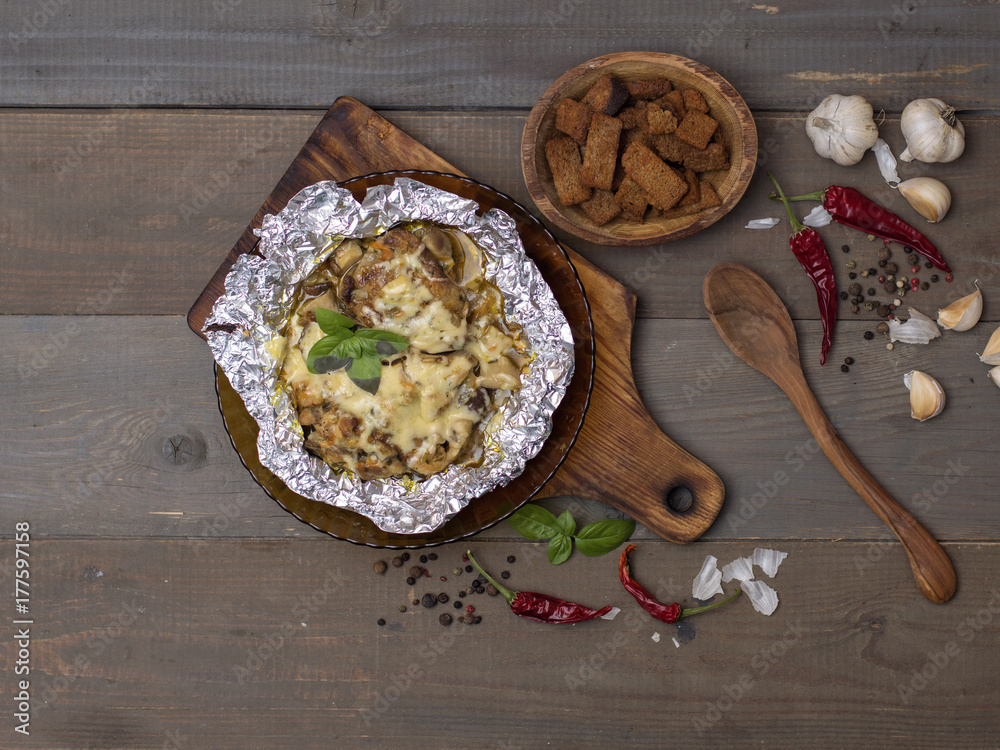 stewed vegetables with meat, mushrooms and cheese on a wooden board. stewed vegetables with meat, mushrooms and cheese on a wooden board.