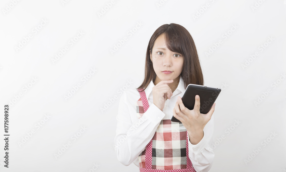 タブレットを持つエプロン姿の女性 タブレットを持つエプロン姿の女性