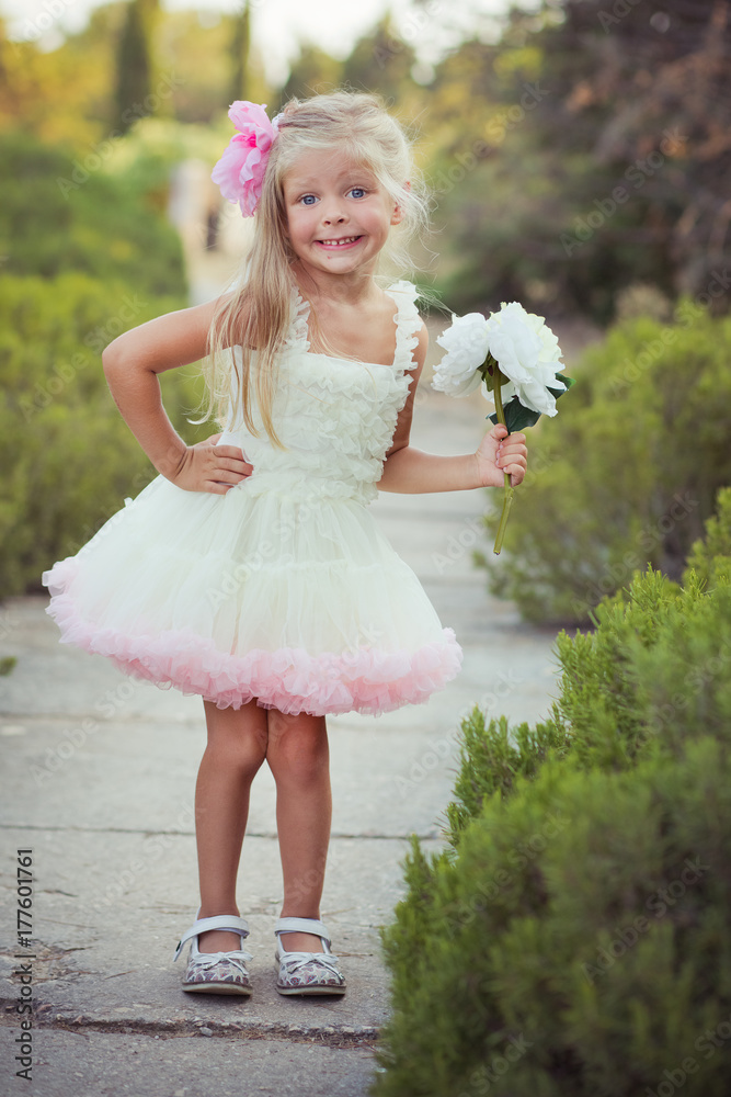 Amazing deep blue eyes baby girl child stylish dressed in colourful pink  dress with shining blond
