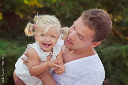 Family scene handsome young dad father posing playing with his baby daughter in central park forest summer meadow Happy life time vacation travel