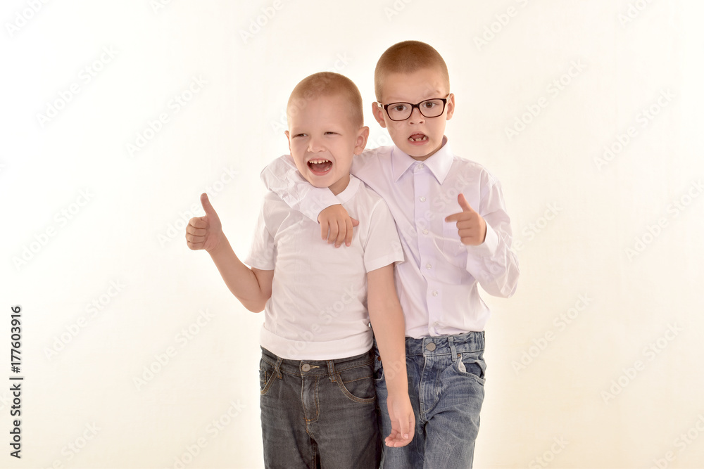 A caucasian elementary age boy with glasses posing in uniform isolated on white background with him brother. School and education concept. A caucasian elementary age boy with glasses posing in uniform isolated on white background with him brother. School and education concept.