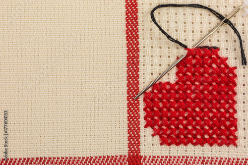 heart embroidered in cross stitch on canvas
