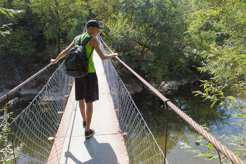 Traveller looking the nature from the suspension bridge. Active and healthy lifestyle on summer vacation and weekend tour