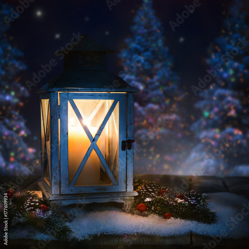 A lantern in front of colorfull  glowing christmastrees