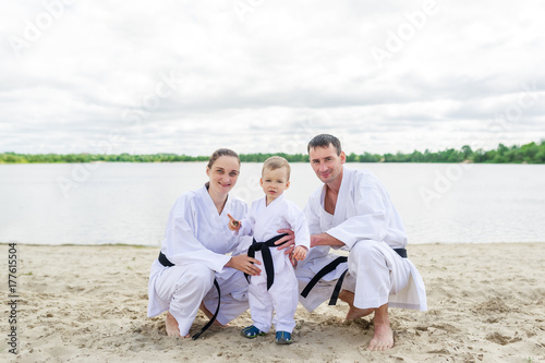 Father, mother and little son - sport family. Young family in kimono outdoors.
