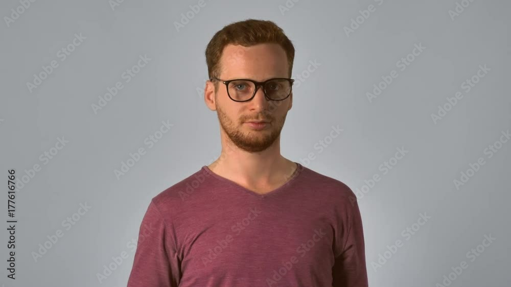 candid caucasian man with red hair posing pushing up eyeglasses looking at the camera. handsome redheaded men wearing in casual t-shirt. Portrait ginger young caucasian man on grey background candid caucasian man with red hair posing pushing up eyeglasses looking at the camera. handsome redheaded men wearing in casual t-shirt. Portrait ginger young caucasian man on grey background