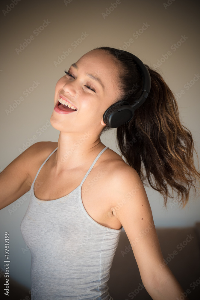 Fototapeta premium Young teen pleasure and joy listening music and dancing at home