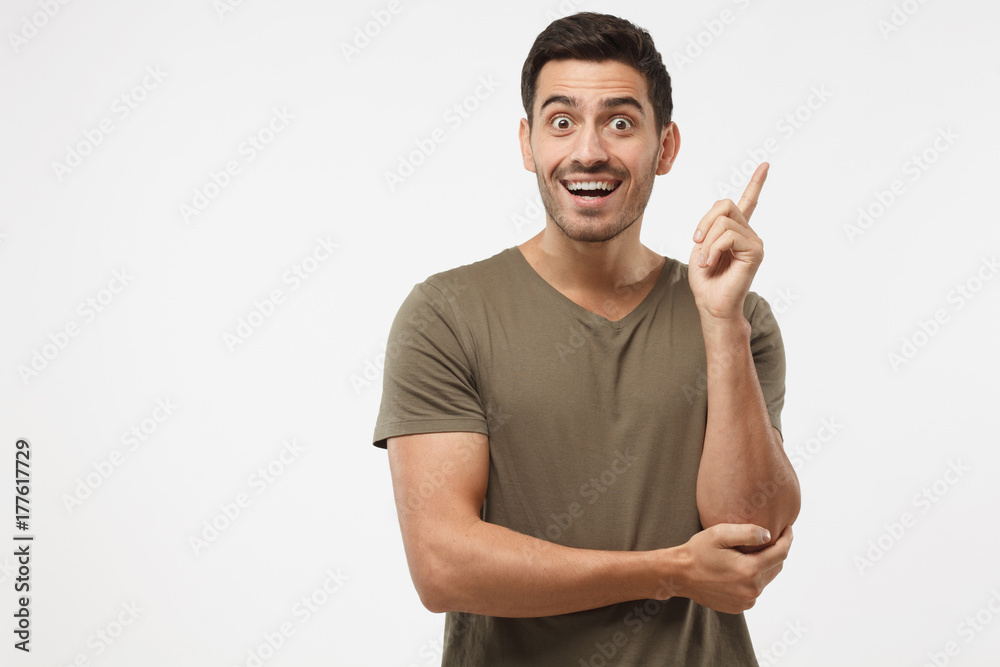 I have a great idea! Young attractive smiling guy keeping finger pointed upwards, showing something above his head, making gesture with index finger I have a great idea! Young attractive smiling guy keeping finger pointed upwards, showing something above his head, making gesture with index finger