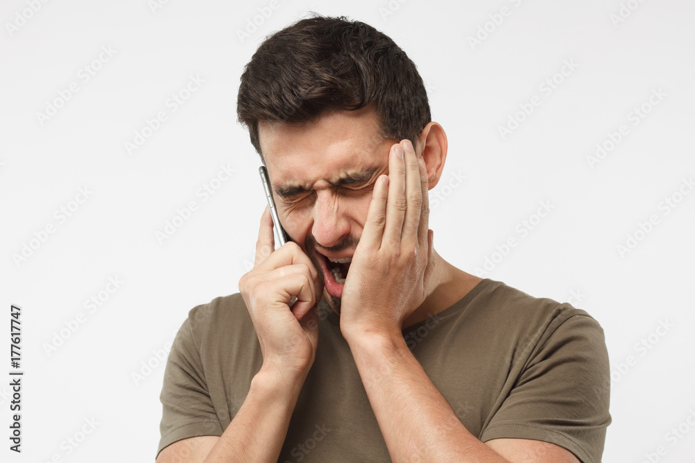 Close up portrait of bored guy, yawning because boring talk with boss, want to sleep, closing his mouth by hand, isolated on gray background Close up portrait of bored guy, yawning because boring talk with boss, want to sleep, closing his mouth by hand, isolated on gray background