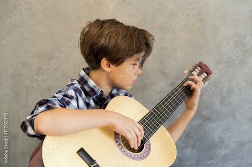 Teen boy playing acoustic guitar photo