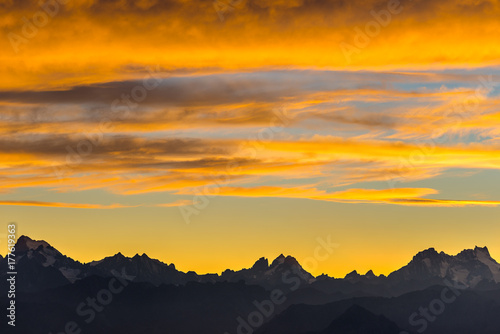 Sunset over the Alps. Colorful sky  high altitude mountain peaks with glaciers  Massif des Ecrins National Park  France. Telephoto view from distant.