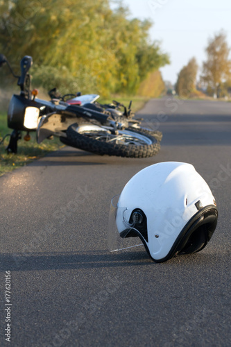 Photo of helmet and motorcycle on the road, the concept of road accidents