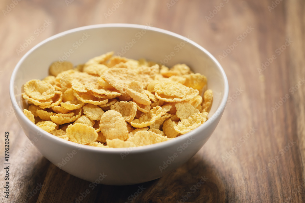 corn flakes in white bowl on table closeup corn flakes in white bowl on table closeup