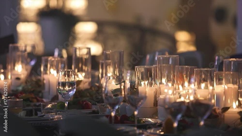 Decorative candles on the dining table, glasses and Christmas candles on the table, white wax candleswith glass candlestick, Candle with Glass Candlestick, restaurant, interior, close-up photo