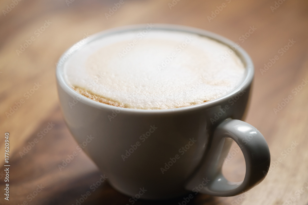 Fototapeta premium fresh cappuccino with chocolate flakes on wood table