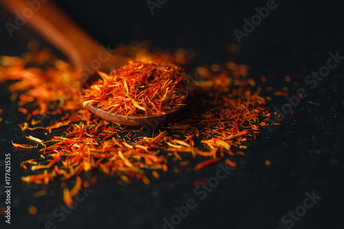 Saffron in a spoon on a dark background, selective focus, macro shot, shallow depth of field photo