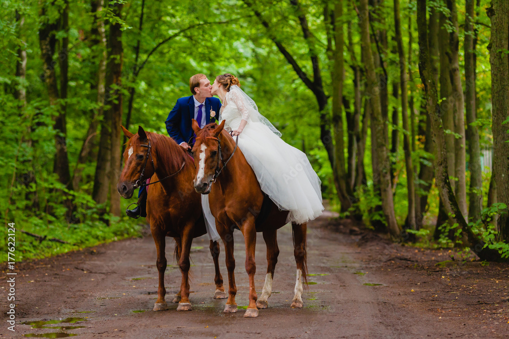 Beautiful newlyweds riding two horses Beautiful newlyweds riding two horses