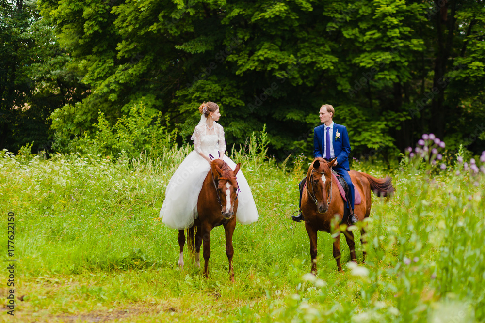 Beautiful newlyweds riding two horses Beautiful newlyweds riding two horses