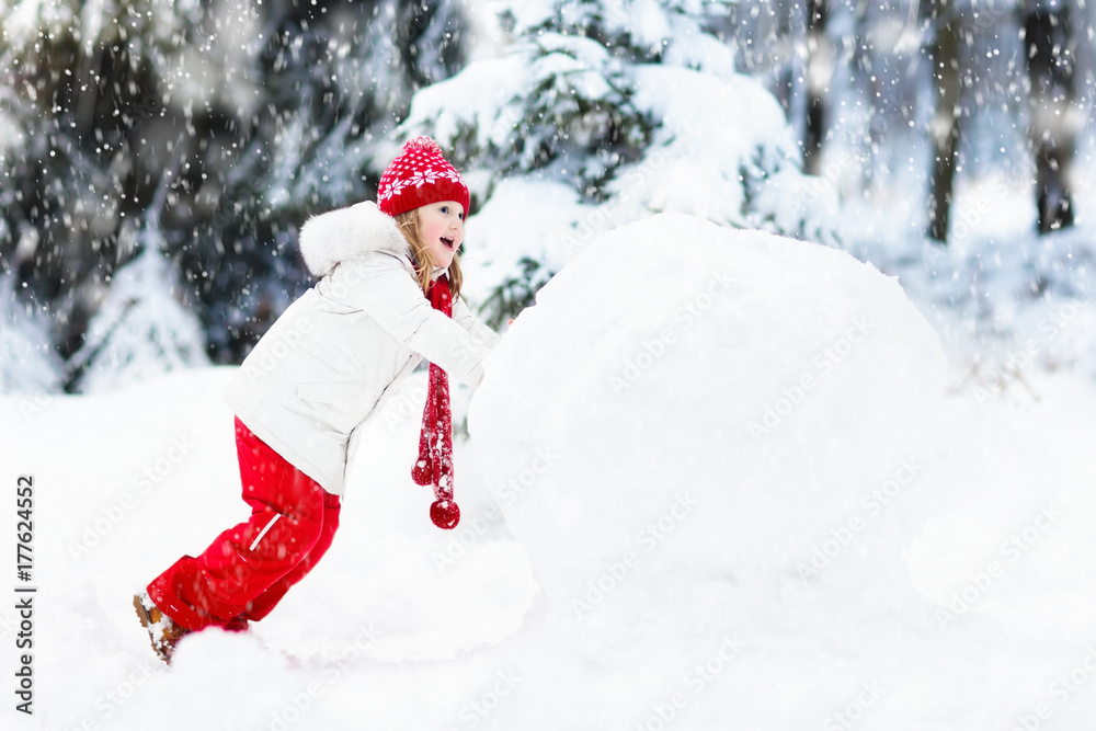 Kids building snowman. Children in snow. Winter fun.