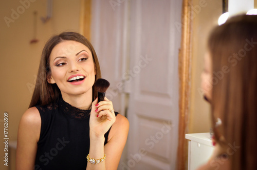 beautiful sexy woman wearing makeup looking in the mirror.smiling at her reflection in the mirror  